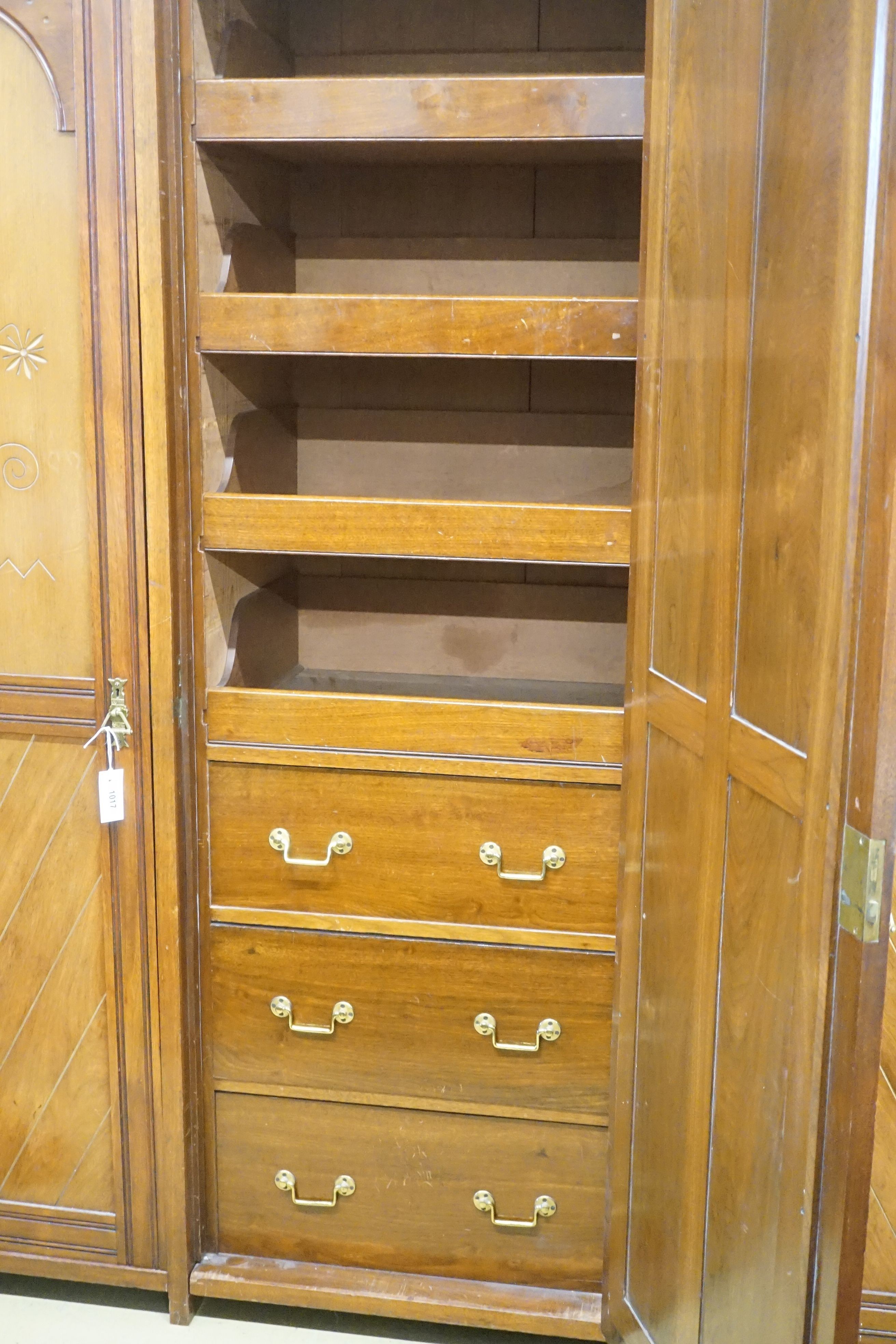 A late Victorian aesthetic movement walnut triple wardrobe, width 187cm depth 56cm height 203cm